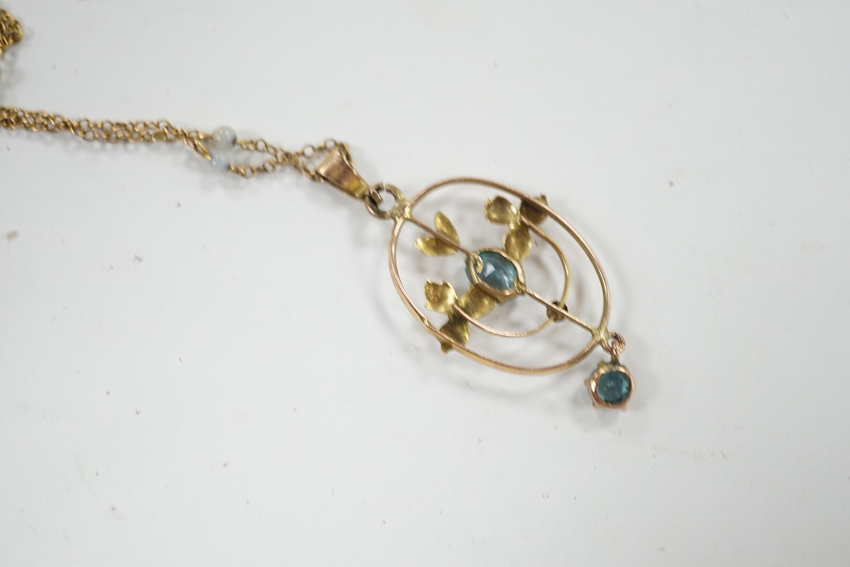 An Edwardian 9ct and gem set drop pendant, 39mm, on a later 9ct and simulated pearl set chain, 42cm. Condition - poor to fair